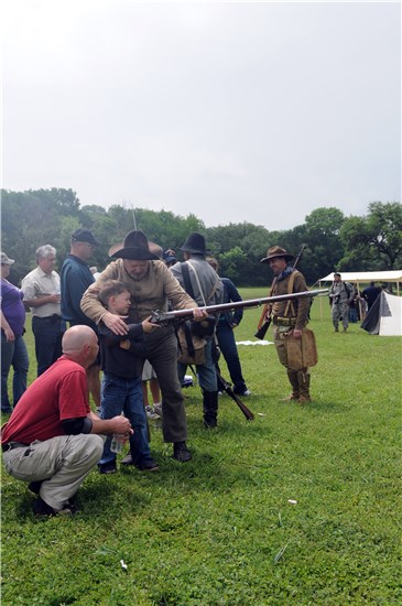 Aaron Black, an Austin native and father to Hal R. Black, watches as his son is assisted by living historian Lee R. Chesney in firing a rifle at the Texas Revolution and Civil War weapons demonstration at the 4th Annual American Heroes Celebration at Camp Mabry.