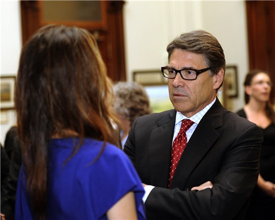 Texas Gov. Rick Perry visits with Taya Kyle, wife of slain Navy SEAL Chris Kyle, following the signing of Senate Bill 162 at the Texas State Capitol, in Austin, Texas, Aug. 28, 2013. 