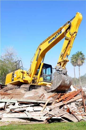 Tech Sgt. Carl White Jr., 147th Civil Engineers, 147th Fighter Wing, Texas Air National Guard, uses the heavy 45,000 pound Komarsu excavator to crunch rubble from a destroyed house into smaller pieces ready to be transported to a local landfill, Harlingen, Texas, Dec. 16, 2013.