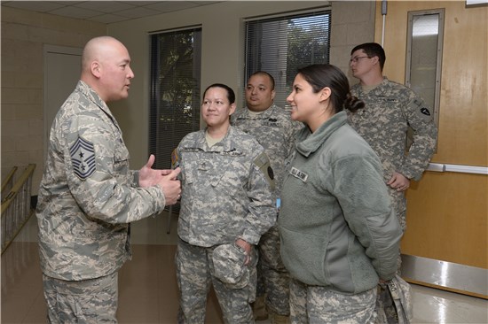 National Guard Bureau senior enlisted leader Command Chief Master Sgt. Mitchell Brush takes time to meet with Staff Sgt. Nayda Troche, center, and Spc. Jennifer Cubero, Texas Medical Command, Texas Army National Guard, after his town hall meeting held at Camp Mabry in Austin, Texas, Feb. 9, 2014.