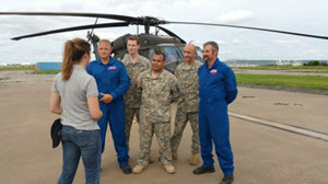 A meteorologist interviews members of Texas Task Force 1 and the Texas Army National Guard at the Army Natioanl Guard aviation support facility, in Grand Prairie, Texas, May 17, 2015. The combined team rescued a couple in distress early in the day and brought them to safety. (U.S. Air National Guard photo by Senior Master Sgt. Elizabeth Gilbert/Released)