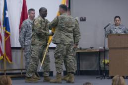 Sgt. Josiah Pugh Brig. Gen. Sean A. Ryan passes the colors from the 136th Regiment's outgoing commander, Col. Michael Adame, to the unit's incoming commander, Col. Carlton Smith, during a change of command ceremony held at the Camp Mabry Simpson Auditorium on April 14, 2016. The ceremony represents the change of responsibility from one commander to another. (U.S. Army National Guard photo by Staff Sgt. Josiah Pugh)