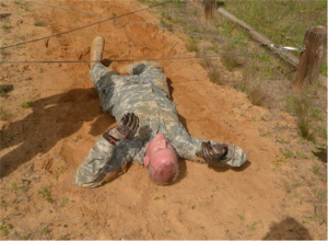 After successfully clearing the low-crawl obstacle on his stomach, Officer Candidate Michael Ross goes for round 2 on his back. Photo Credit Captain Shaw James