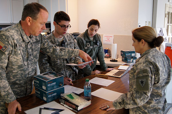 Staff Sgt. Michael Mills, Spc. Adam Poncher, Spc. Kelly Bach, and 1st Lt. Lana Cameron, 2nd Regiment, Texas State Guard, review registration documents at the mass care shelter at St. Luke’s Episcopal Church in Stephenville, Texas, January 22, 2016.  Mass care sheltering is an essential skill that the Texas State Guard can provide to assist local residents during an emergency. (Photo by Spc. Stefan Wray, 2nd Regiment/ Released)