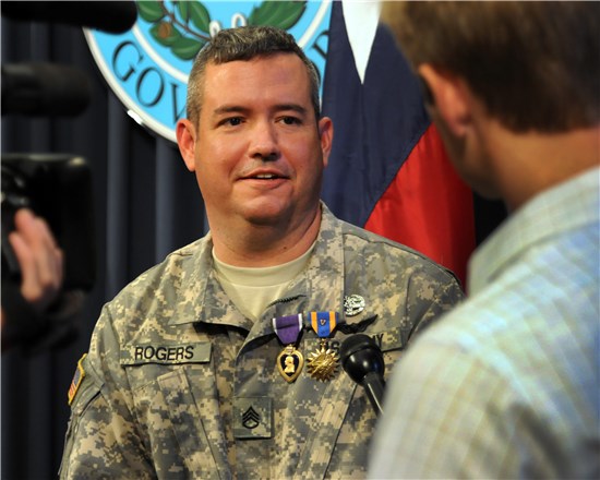 Staff Sgt. Patrick D. Rogers, Jr., a flight medic and member of the Texas Army National Guard, visits with a news reporter after being presented the Purple Heart, the Air Medal with "V" Device for Valor and the Combat Medical Badge from Texas Gov. Rick Perry at the Texas State Capitol in Austin, Texas, Nov. 1, 2012. 