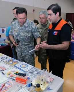 Sgt. Suzanne Carter Representatives of Chilean military and a Chilean national emergency response agency examine samples of sugar contents in popular beverages at a health awareness booth during Operation Lone Star in Laredo, Texas, Aug. 6, 2014. The officials visited Operation Lone Star to see how multiple agencies collaborate to plan and implement this annual medical and emergency preparedness exercise. The Operation Lone Star partnership between Texas Military Forces, Texas Department of State Health Services and other state and local agencies has provided much needed health care services to more than 100,000 Laredo and Rio Grande Valley residents since 1999. (U.S. Army National Guard photo by Sgt. Suzanne Carter)