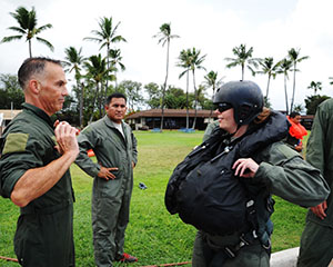 Brig. Gen. Gregory Woodrow, commander of the 154th Wing, assists Master Sgt. Jacqueline Crow, Operations Intelligence Analyst, with operating the parachute release as Tech. Sgt. Kevin Yamaguchi, crew chief, both of the 149th Fighter Wing, Texas Air National Guard, headquartered at Joint Base San Antonio-Lackland, Texas, observes at Joint Base Pearl Harbor-Hickam, Hawaii, Aug. 22, 2016. All members completed water survival training as a requirement prior to taking a flight with the 149th F-16 Fighting Falcons as part of the Sentry Aloha 2016, a large-scale fighter exercise hosted by the Hawaii Air National Guard. (U.S. Air National Guard photo by Tech. Sgt. Rebekkah Jandron)
