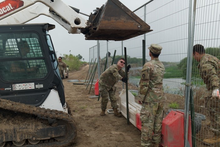 Soldier setting up fence 