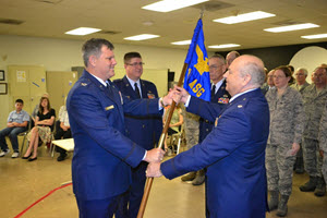 Col Thomas (Pre) Ball (left) presents the 447th ASG Guidon to Lt Col Barry Dolgow, new Commander 447th ASG (right), while Lt Col Patrick Cassidy, former commander looks on (center). (Photos by Capt Shawn James)